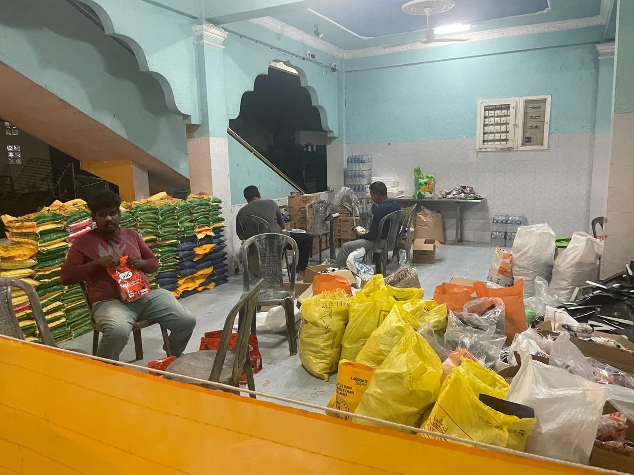 Volunteers packing dry rations and supplies into bags late at night before distribution.